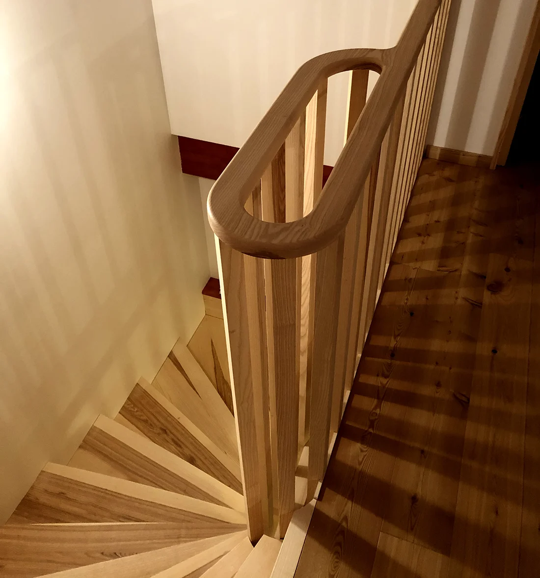 Escalier en bois sur mesure avec garde-corps et main courante cintrée aux finitions haut de gamme
