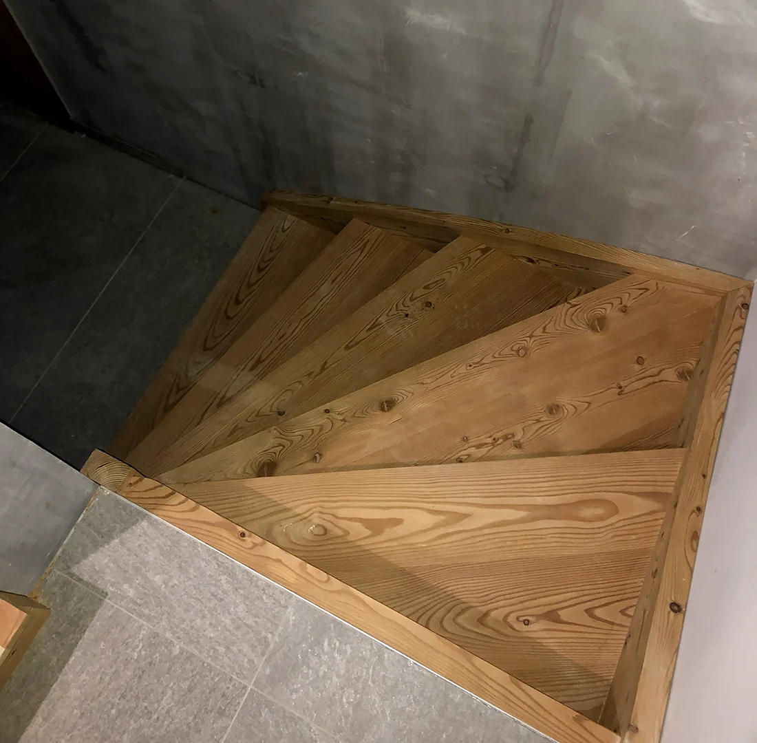 Escalier quart tournant en bois massif sur mesure intégré dans un angle avec marches sur mesure