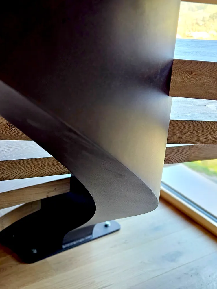 Détail de limon courbe en métal pour escalier bois sur mesure avec finition soignée
